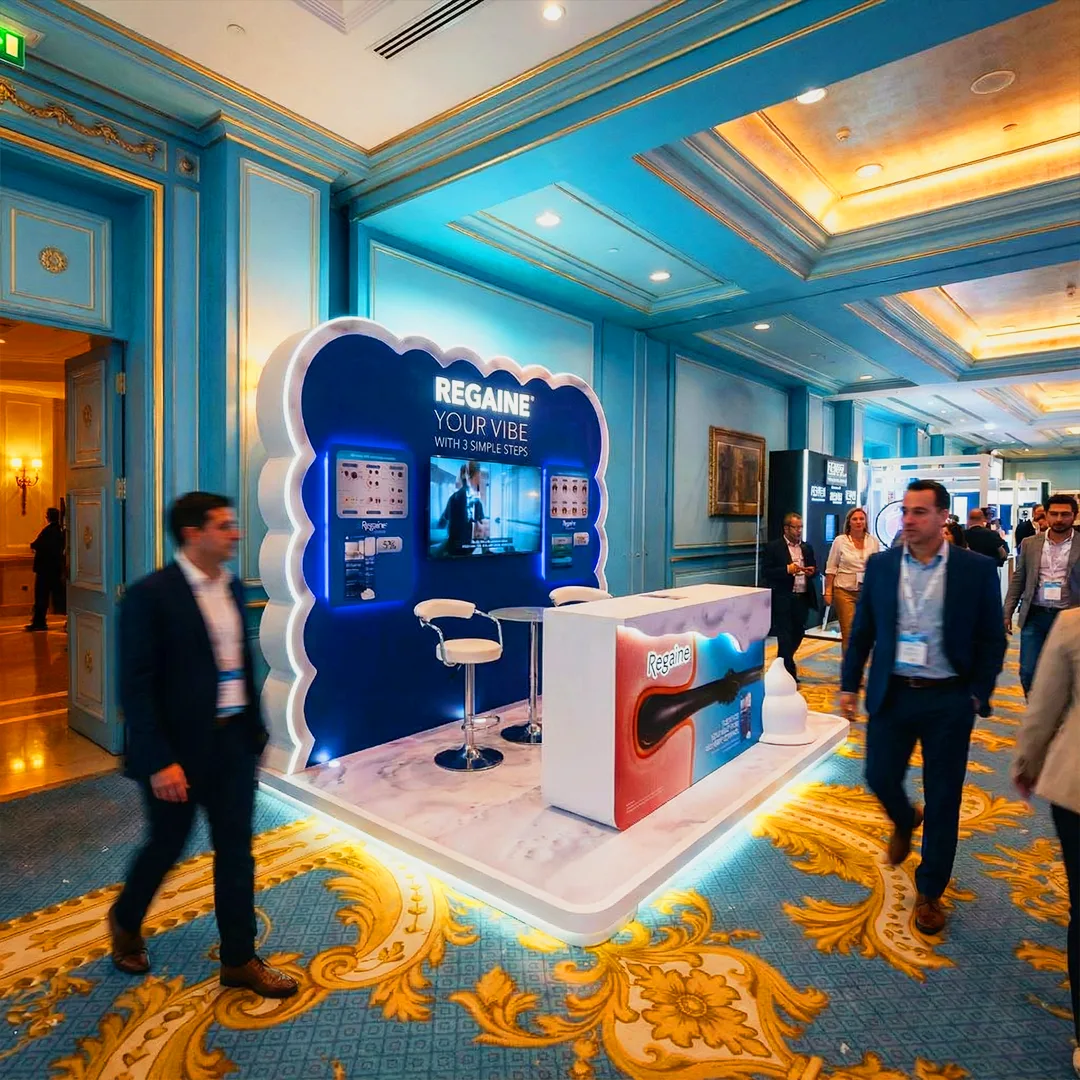 Regaine promotional booth with cloud-shaped backdrop, illuminated branding, and product demo screen at upscale event