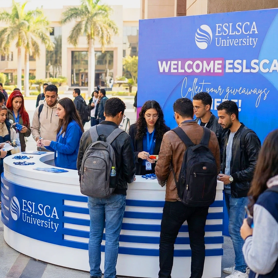 ESLSCA University outdoor welcome booth with students collecting giveaways and staff engaging during orientation